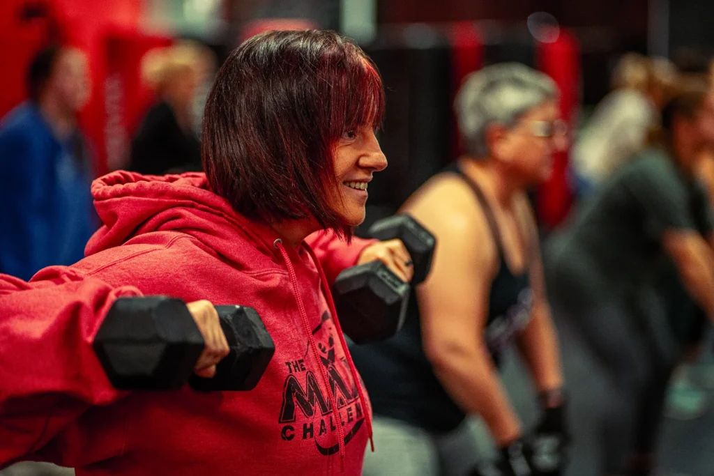 woman exercising in group fitness class with dumbells